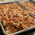 Looking for a quick and irresistible holiday treat? This Pecan Pie Bark is the perfect answer. Made with buttery caramel, crunchy pecans, and a crisp cracker base, it tastes just like pecan pie but in candy form. It’s easy to make in under an hour, requires simple ingredients, and is perfect for gift-giving, cookie trays, or just snacking during the holidays. The beauty of pecan pie bark is its simplicity—you don’t need a pie crust or hours in the kitchen. Just layer crackers, pour on caramel, bake, and break into crunchy, gooey pieces. Ingredients 1 sleeve graham crackers or saltine crackers (about 12–14) 1 cup unsalted butter (2 sticks) 1 cup brown sugar 1 tsp vanilla extract 2 cups chopped pecans 1/2 tsp cinnamon (optional) Pinch of salt 1/2 cup melted chocolate (optional, for drizzling) Preparation Steps Step 1: Preheat Oven Preheat oven to 350°F (175°C). Line a baking sheet with parchment paper or foil. Step 2: Layer Crackers Arrange crackers in a single layer on the prepared baking sheet. Step 3: Make Caramel In a saucepan, melt butter and brown sugar over medium heat. Bring to a boil and cook for 3 minutes, stirring constantly. Remove from heat and stir in vanilla. Step 4: Add Pecans Pour caramel mixture evenly over crackers. Sprinkle chopped pecans, cinnamon, and salt on top. Step 5: Bake Bake for 10–12 minutes, until bubbly and golden. Step 6: Cool and Break Allow to cool completely. Break into bark pieces. Optional: drizzle with melted chocolate before cooling. Variation Chocolate Pecan Pie Bark: Spread melted chocolate over the top after baking. Maple Pecan Bark: Replace brown sugar with maple syrup for a twist. Spiced Bark: Add nutmeg, allspice, or pumpkin spice to the caramel. Salted Caramel Bark: Sprinkle with flaky sea salt after baking. Cooking Notes Use parchment paper for easy removal. Watch carefully while baking to avoid burning the caramel. Break into rustic pieces once cooled—it’s meant to look fun and homemade. Serving Suggestions Add to holiday cookie platters or gift tins. Serve with coffee or hot chocolate. Pack in decorative bags for edible gifts. Tips Toast pecans before adding for a richer flavor. Use saltines for a salty-sweet version, or graham crackers for more sweetness. Store in an airtight container for up to a week. Prep Time / Cooking Time / Total Time Prep Time: 10 minutes Cooking Time: 12 minutes Total Time: ~45 minutes (includes cooling) Nutritional Info (per piece, approx. 24 pieces) Calories: 180 Protein: 2g Carbs: 20g Fat: 11g Sodium: 90mg FAQs Q1: Can I use honey instead of brown sugar? Yes, but the texture will be slightly softer than classic caramel. Q2: Can I freeze pecan pie bark? Yes, freeze in layers with parchment paper for up to 2 months. Q3: Can I make this nut-free? Yes, use sunflower seeds or leave out nuts entirely for a toffee-only bark. Q4: Do I need a candy thermometer? No, just boil the butter and sugar for about 3 minutes for perfect caramel. Q5: Can I make it ahead of time? Yes, it stores well at room temperature for a week and is perfect for make-ahead holiday treats. Conclusion This Pecan Pie Bark is a quick, easy, and crowd-pleasing treat that brings all the flavors of pecan pie into a crunchy candy form. With its buttery caramel, toasted pecans, and crispy base, it’s perfect for holidays, gift-giving, or anytime you need a sweet Southern-inspired snack. Once you try it, you’ll want to make it every holiday season!