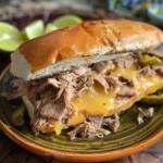 Make this Slow Cooker Cuban Sandwich with tender pulled pork, ham, Swiss cheese, and pickles pressed in buttery bread for the ultimate comfort food!