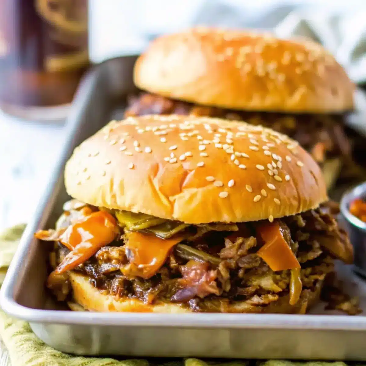 Crockpot Cowboy Sandwiches are bold and hearty with slow-cooked BBQ beef, cheese, peppers, and onions on toasted buns.