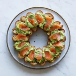 This Smoked Salmon Avocado Crostini Wreath is a stunning, elegant holiday appetizer with creamy avocado, dill, and delicate smoked salmon.